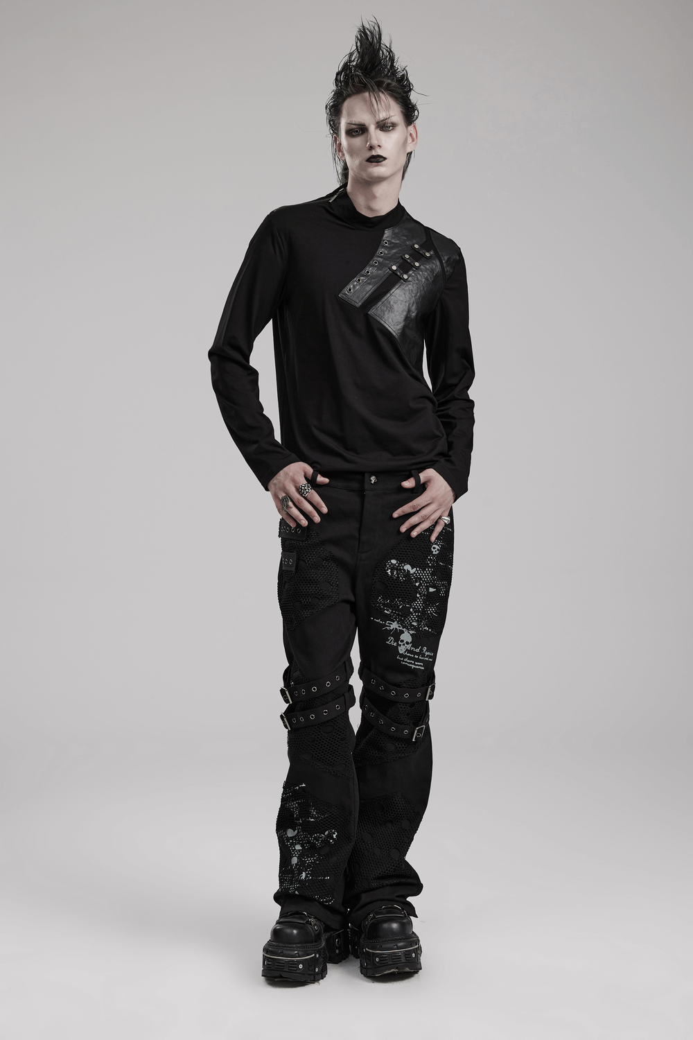 Punk male model in an edgy long-sleeve top with rivet details, showcasing a modern, rebellious style.
