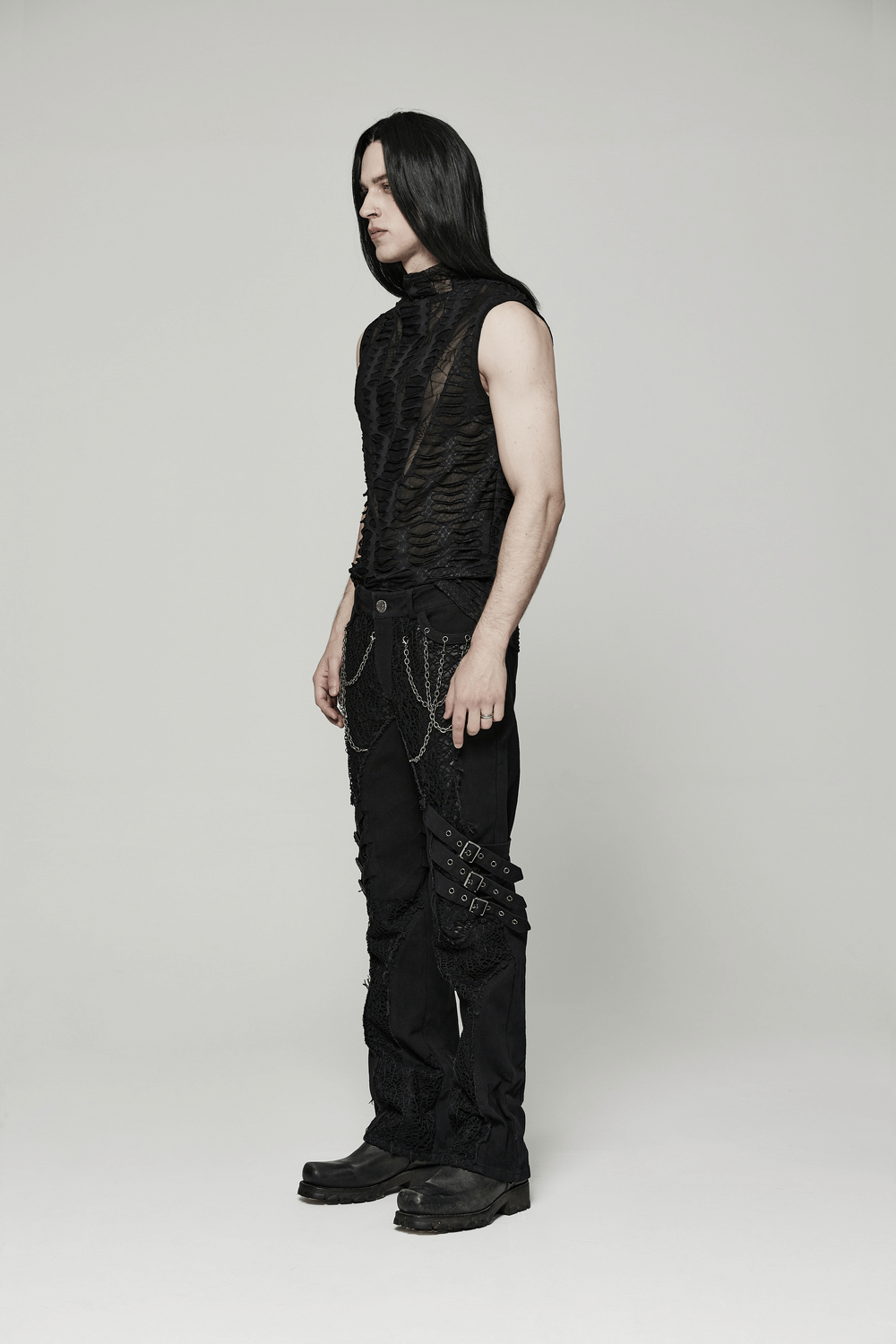 Edgy men's sleeveless gothic top with an asymmetric sharp teeth design, paired with dark pants and stylish boots.