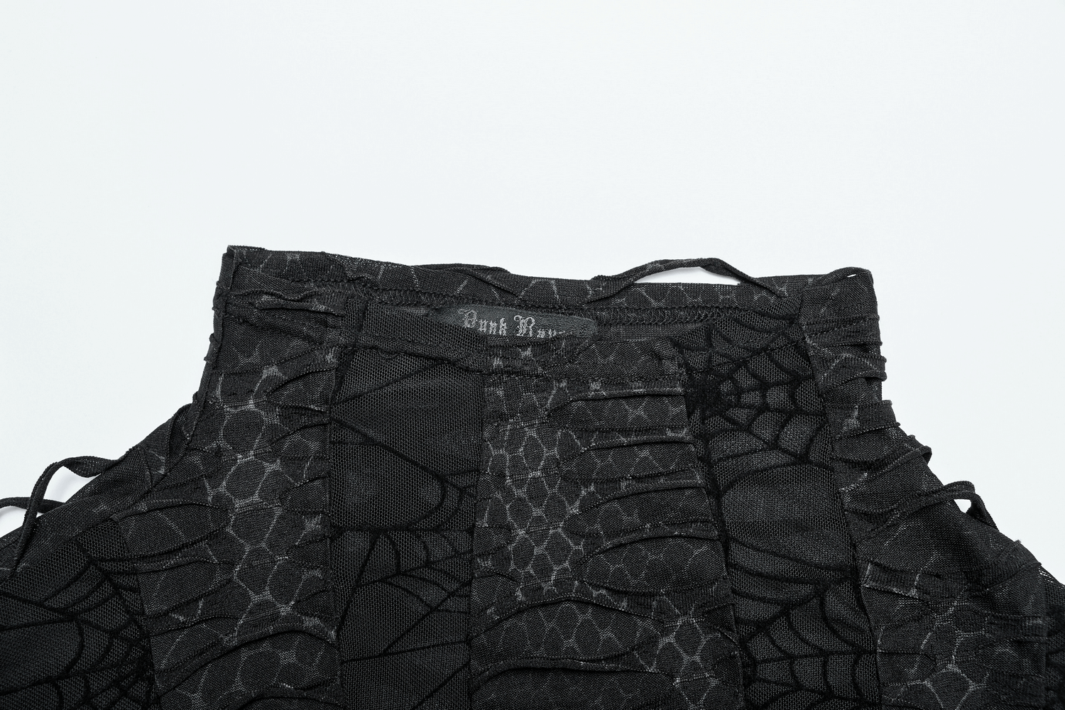 Close-up of black gothic sleeveless top featuring spider web pattern and edgy design details.