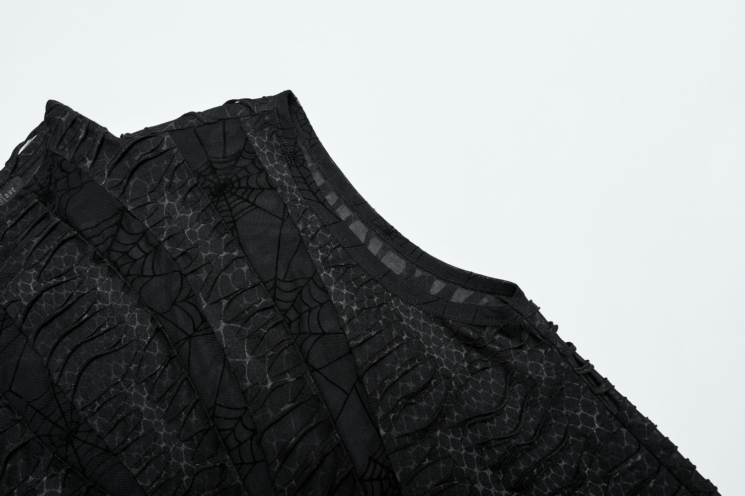 Close-up of black gothic sleeveless top with spider web mesh and asymmetric design for edgy men's fashion.