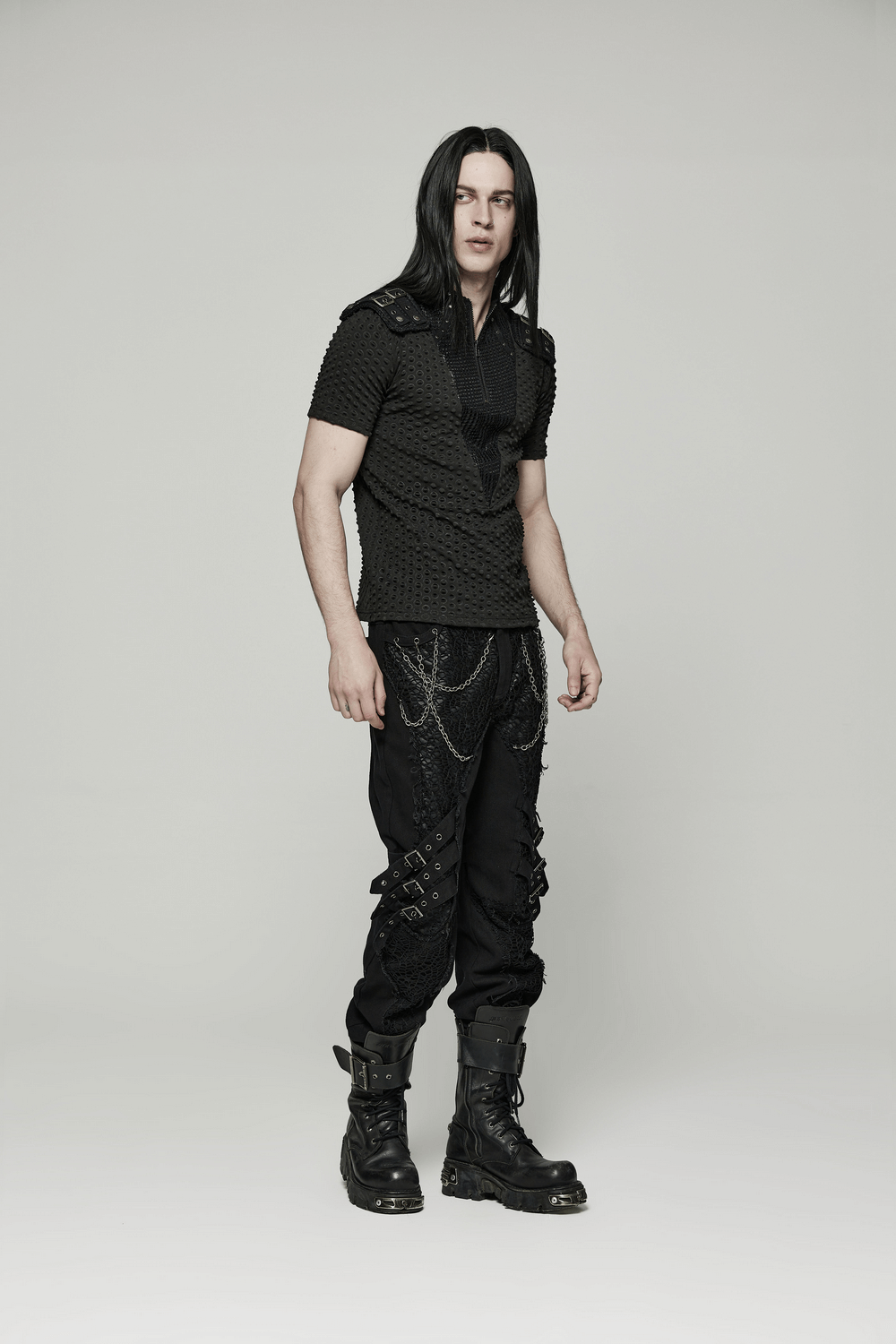 Model wearing an edgy mesh-paneled punk tee with tactical shoulder straps and black cargo pants, showcasing urban style.