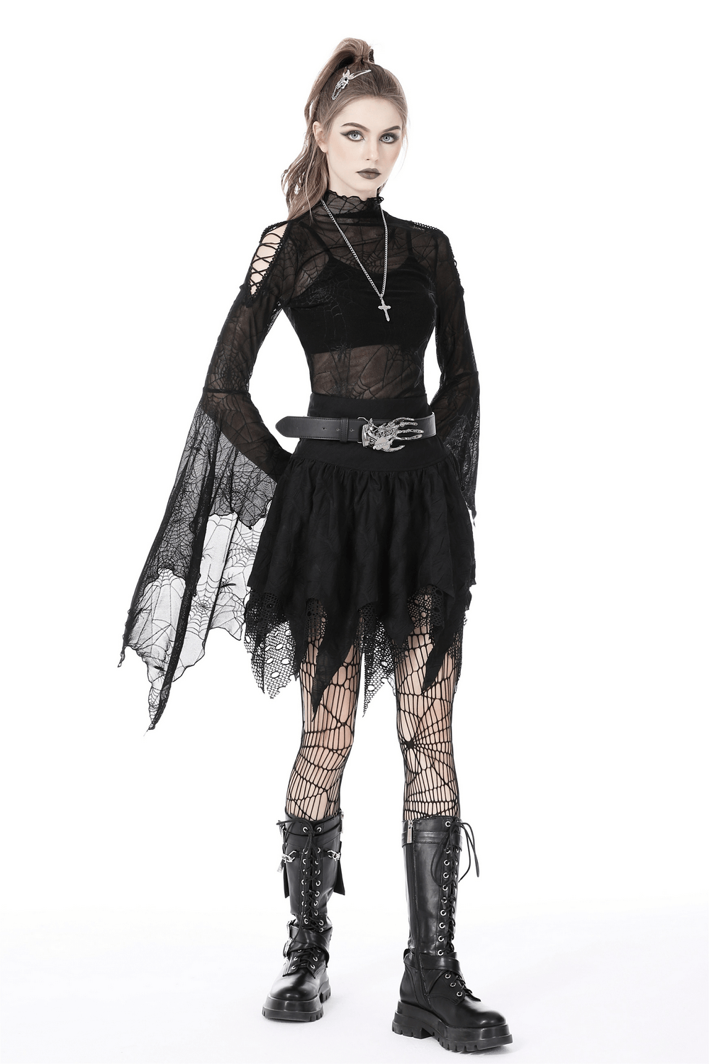 Edgy model in black lace mesh skirt with irregular hem, fishnet tights, and goth-inspired outfit, showcasing dark romance style.
