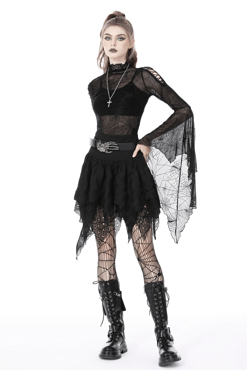Gothic model in black lace mesh skirt with irregular hem and lace trim, layered with fishnet tights and combat boots.