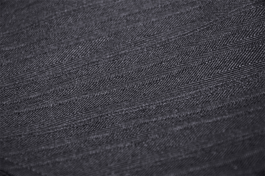 Close-up of textured black fabric with herringbone pattern, ideal for edgy fashion designs.