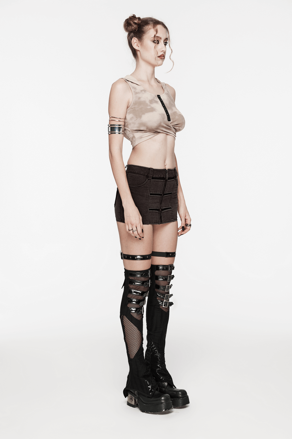 Edgy punk rock outfit featuring a cropped top and mini denim skirt with lace-up knee-high boots.