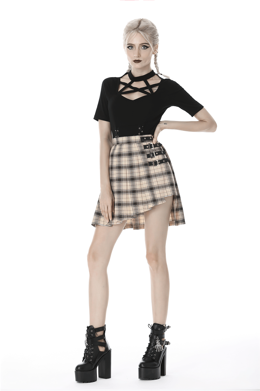 Model wearing an edgy plaid asymmetrical skirt with bold buckles, paired with a stylish black top and platform boots.