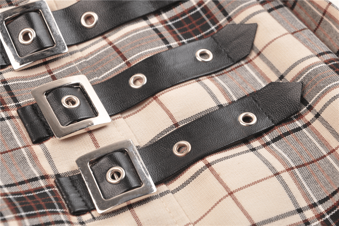 Close-up of edgy plaid fabric featuring bold black buckles and straps, perfect for a trendy asymmetrical skirt.
