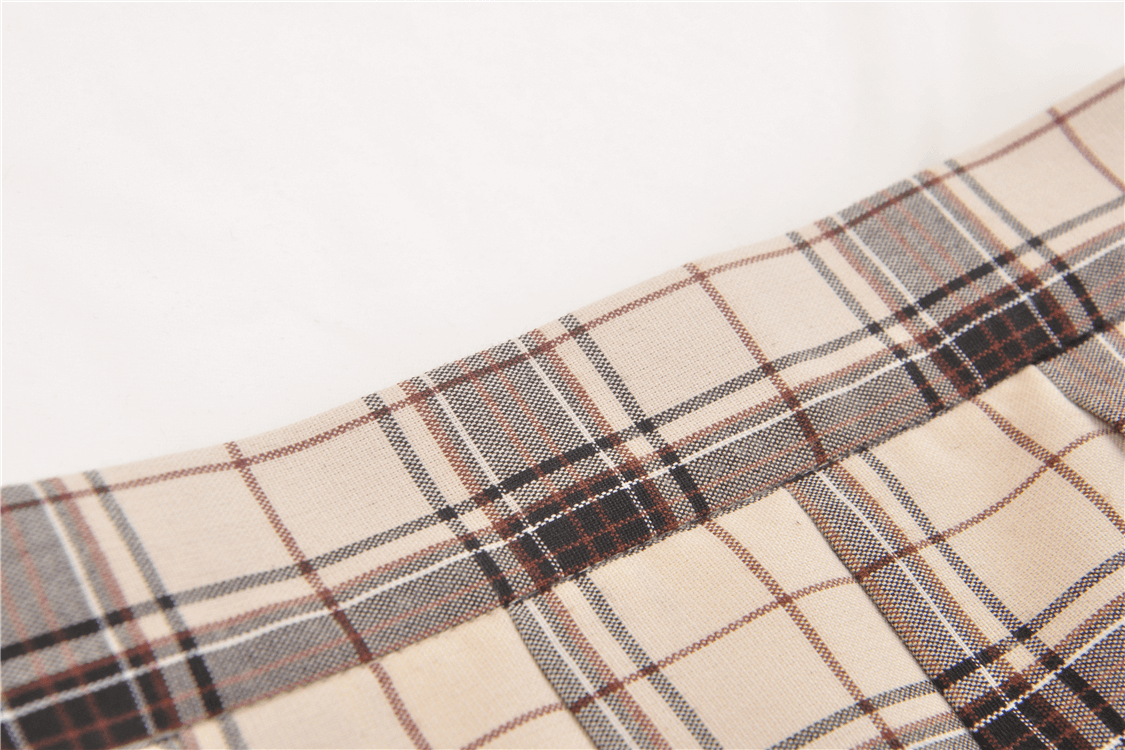 Close-up of trendy plaid fabric showcasing stylish buckle details and chic asymmetrical design.