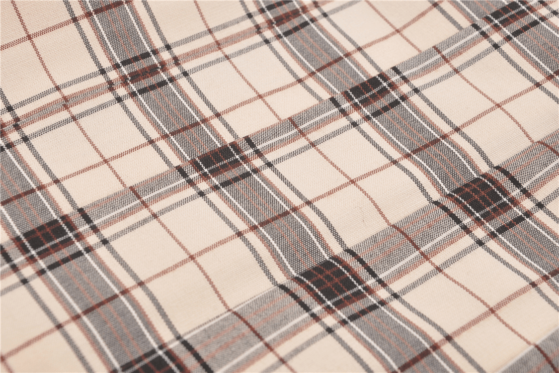 Close-up of trendy plaid fabric with black, gray, and red checkered patterns, perfect for edgy fashion designs.
