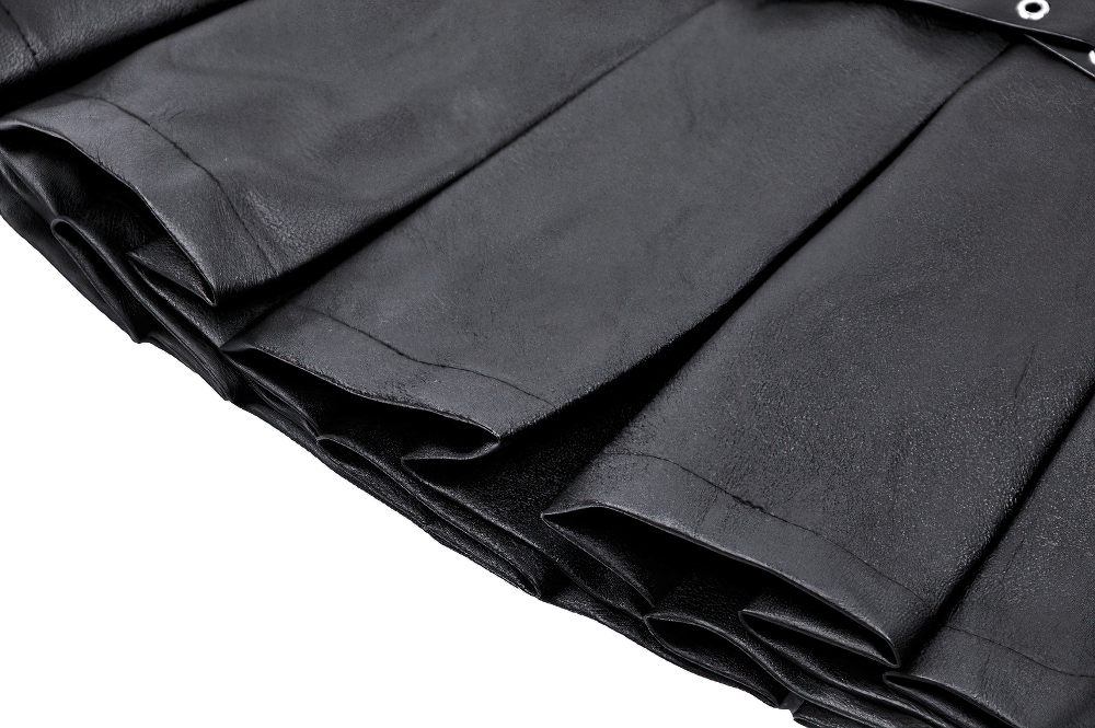 Close-up of the pleats in a black faux leather mini skirt, showcasing shiny texture and edgy design details.