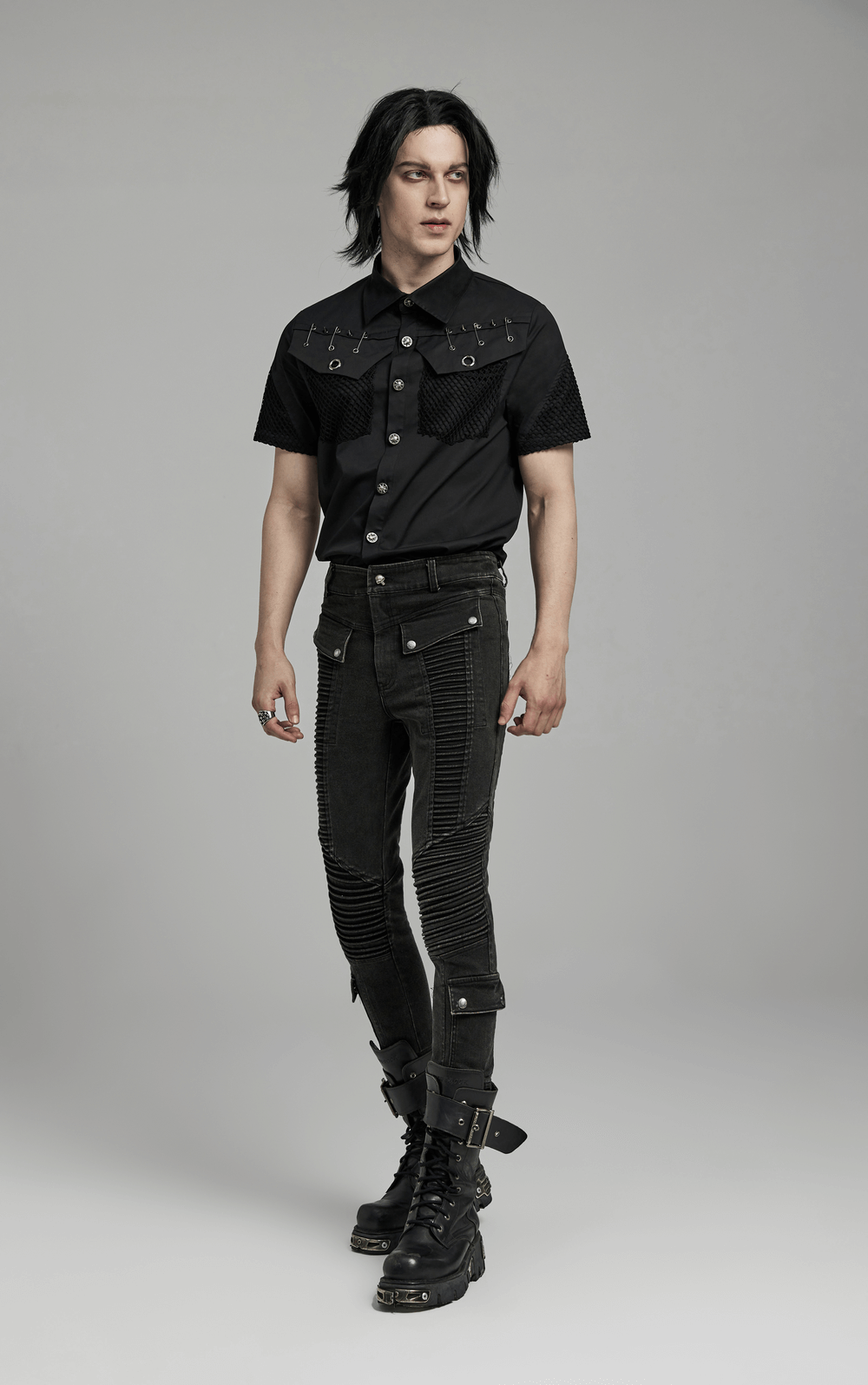 Edgy punk man in black skinny drawstring jeans and stylish top, showcasing unique customized details and slim fit.