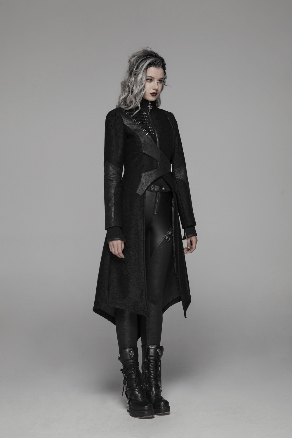 Edgy punk black lace-up long coat with asymmetric design and adjustable waist, styled with leather pants and boots.