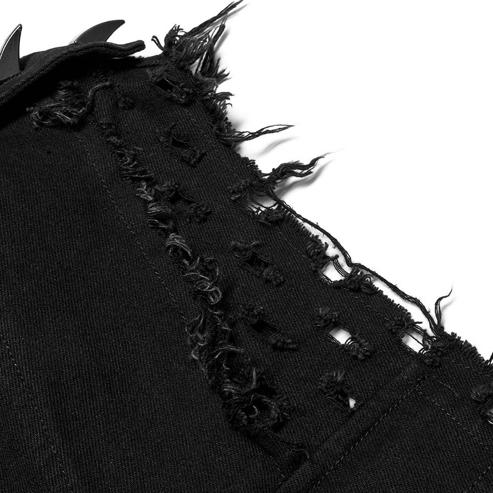 Close-up of distressed black fabric showcasing frayed edges and intentional holes for a punk rock aesthetic.