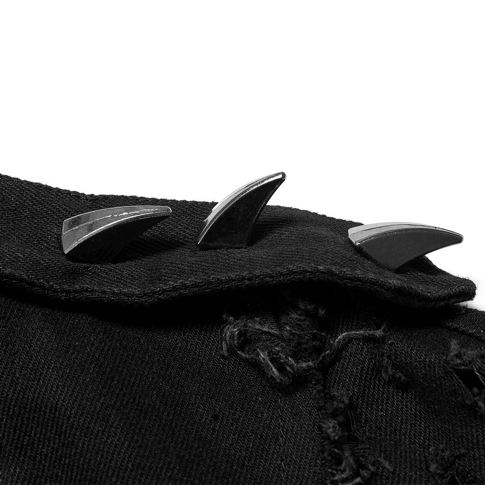 Close-up of edgy black spikes on a distressed cape, showcasing punk rock fashion details.
