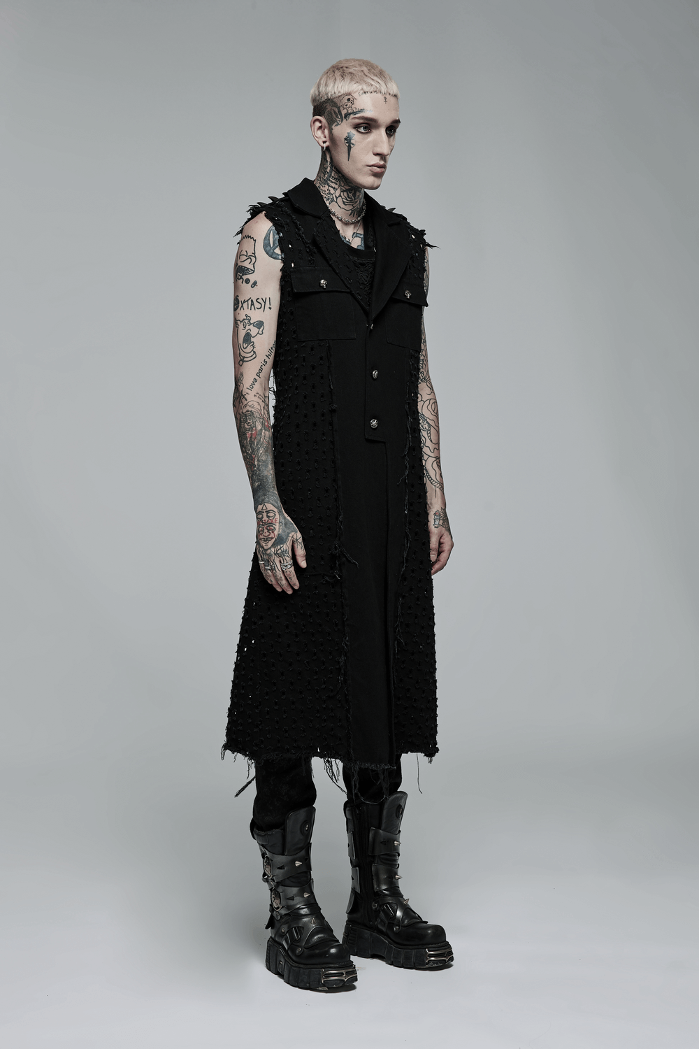 Model wearing an edgy punk medium-length cape with distressed detailing and frayed edges, embodying alternative fashion.