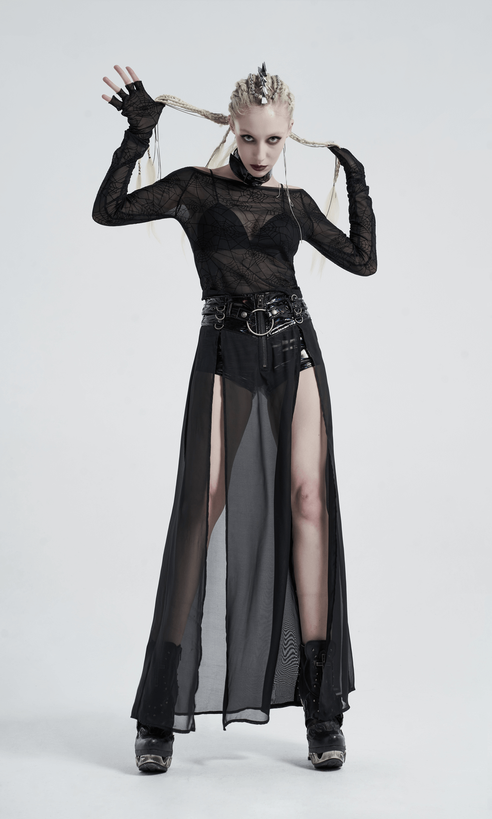 Edgy punk model wearing a black velvet cobweb mesh top with half-cut finger cuffs and a sheer skirt.