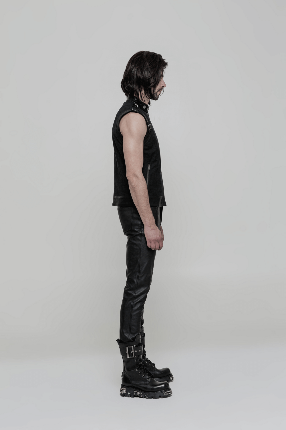 Stylish man in edgy punk black outfit featuring faux leather trousers and platform boots.