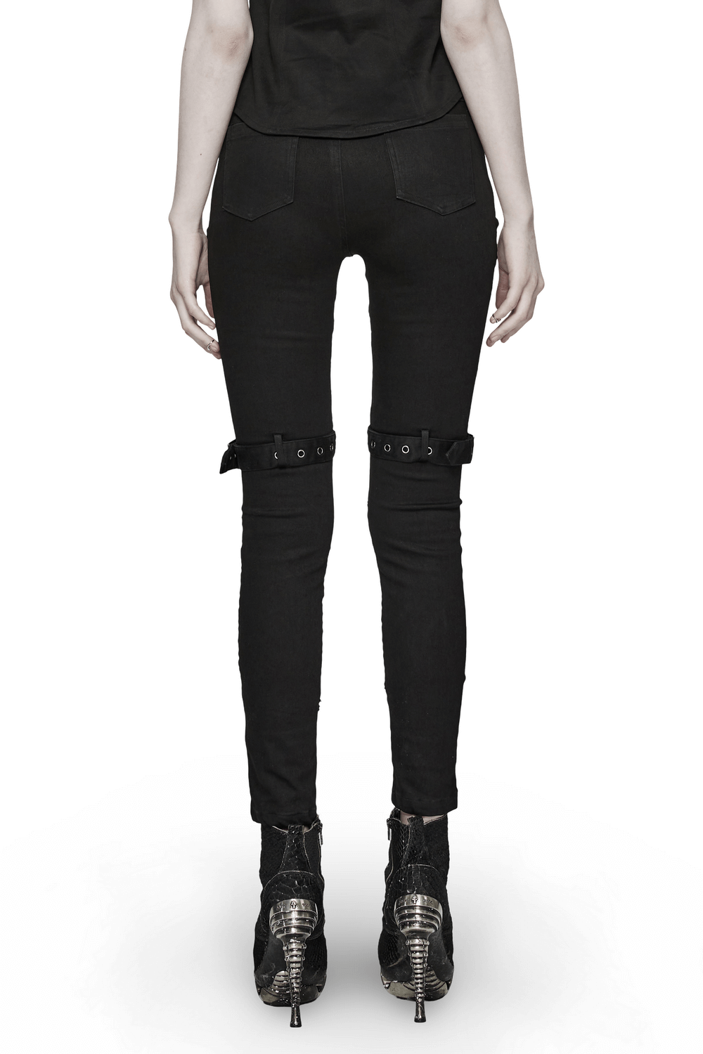 Edgy punk riveted slim jeans with mesh panels and buckles, styled with statement heels from the back.