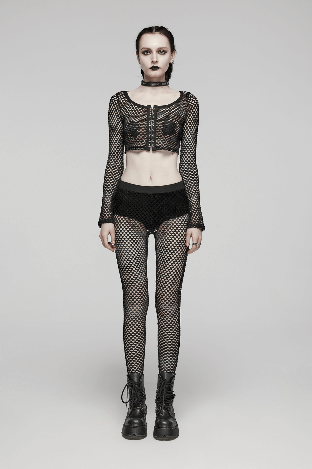 Trendy black mesh punk rock crop top with long sleeves and hooks, paired with fishnet leggings for an edgy look.