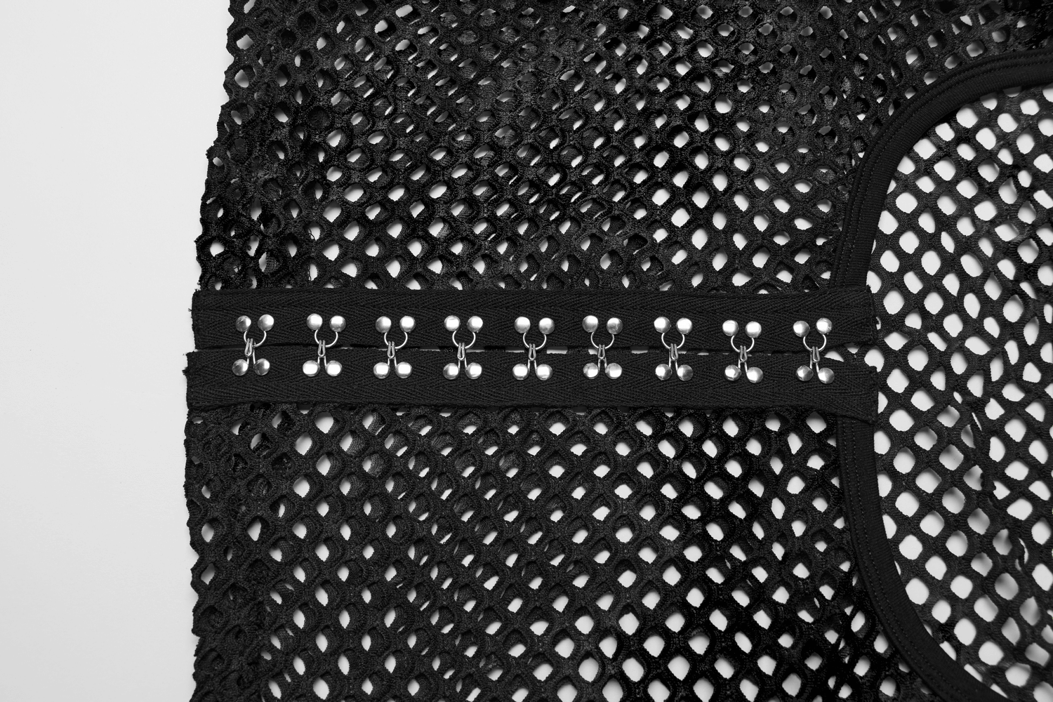 Close-up of black mesh fabric with stylish hooks, showcasing an edgy punk rock design perfect for modern fashion.