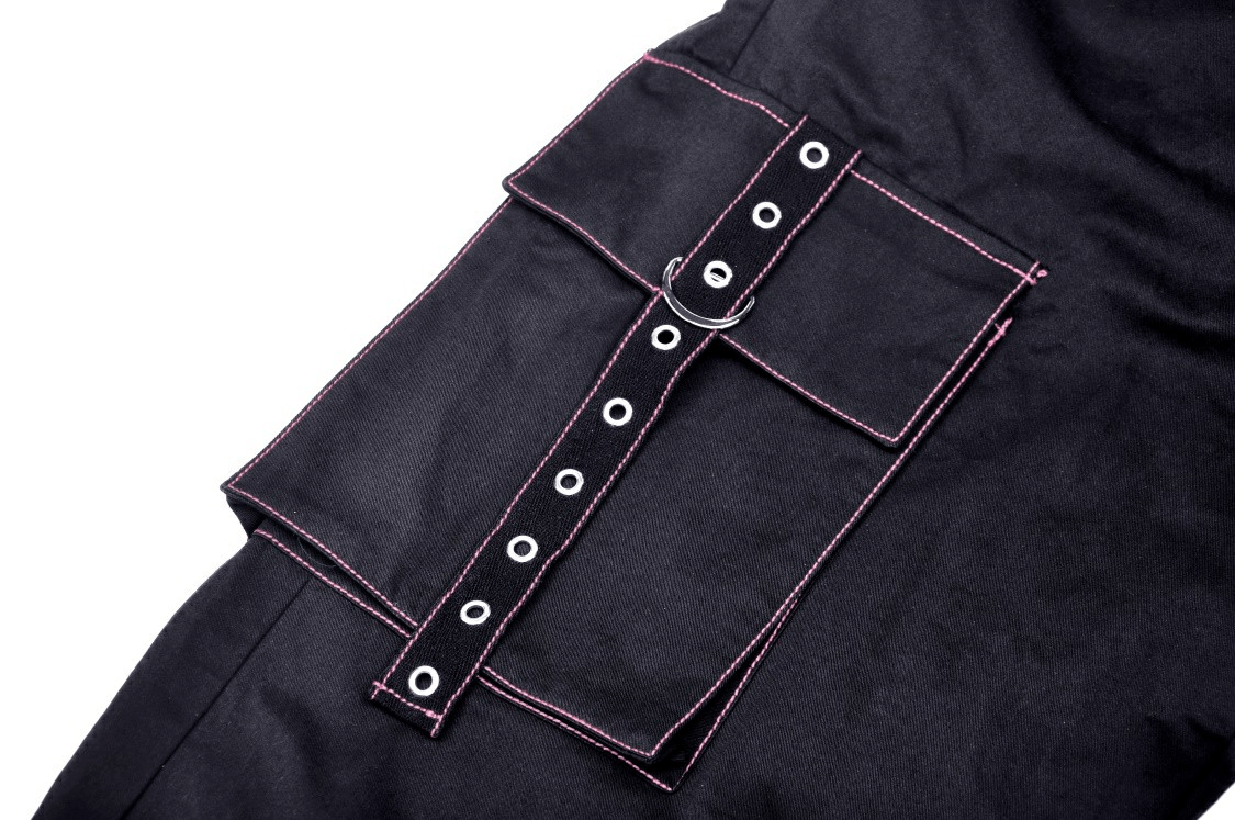 Close-up of black punk rock wide pants with pink stitching and spacious pockets featuring a stylish buckle design.