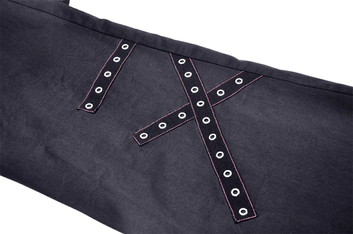Close-up of edgy black punk rock wide pants with bold red stitching and eyelet details.