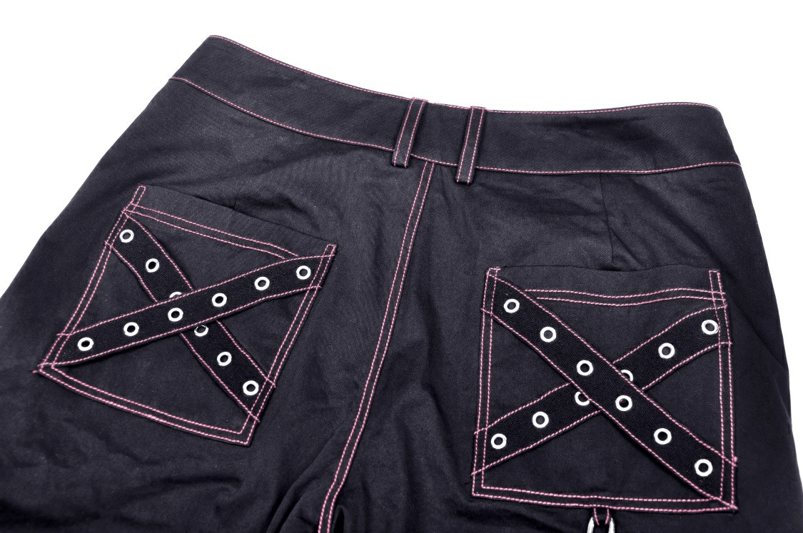 Close-up of edgy punk rock wide pants with chains and pink skull detail on pockets.
