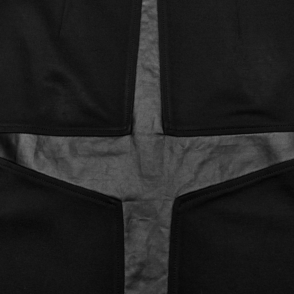 Close-up of edgy punk skirt featuring unique cross splice design and durable fabric contrast for bold style.
