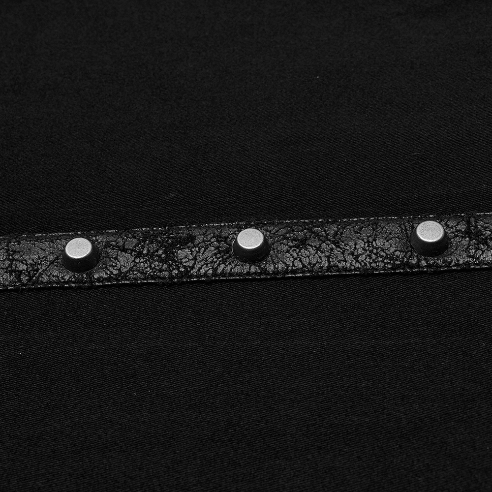 Close-up of edgy punk shirt showcasing rivets on textured black fabric for a unique, urban style.
