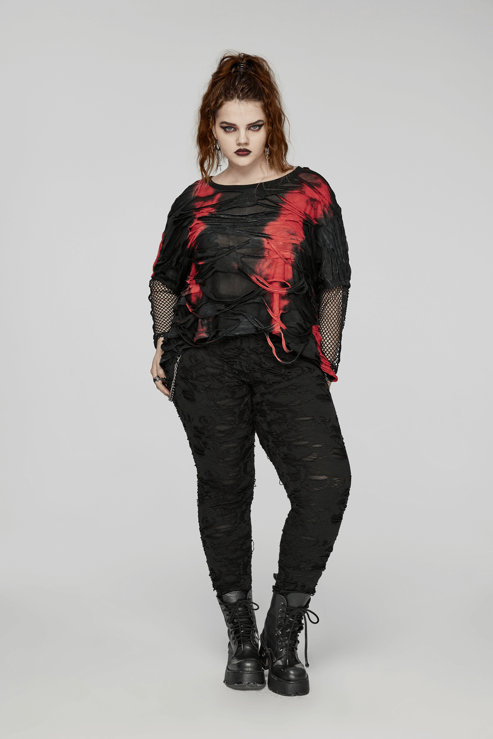 Edgy punk tie-dye top with mesh sleeves, featuring red and black shredded design, showcasing bold alternative fashion for women.