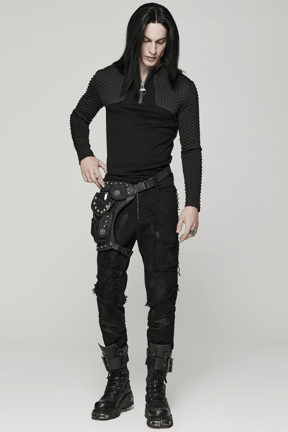 Model wearing edgy punk outfit with textured black top and distressed pants, showcasing a stylish punk aesthetic.