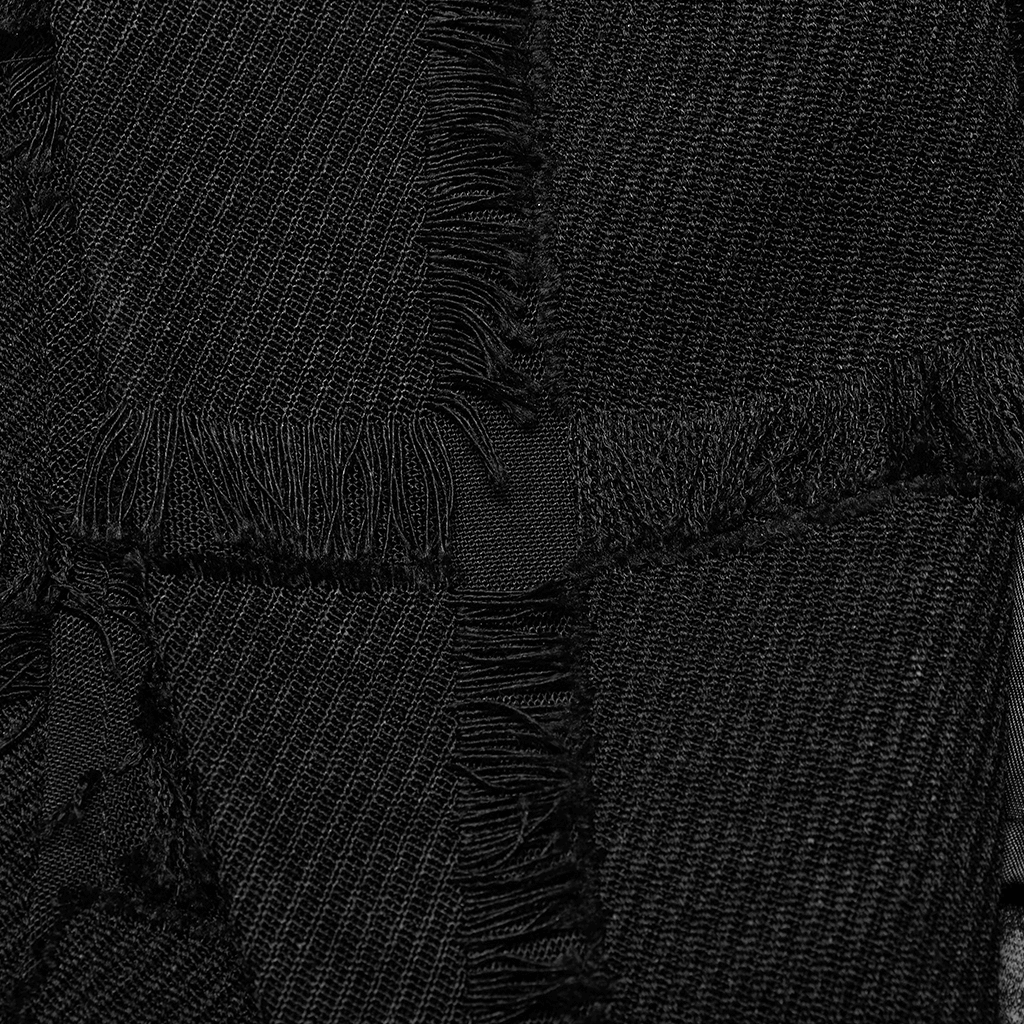 Close-up of textured black wool fabric featuring frayed edges and patches, perfect for punk vest designs.