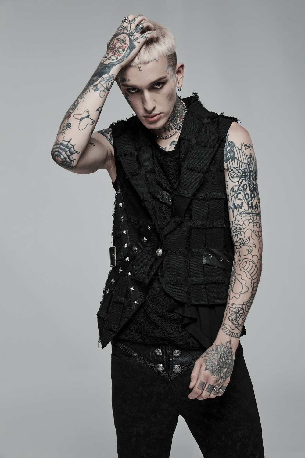 Edgy punk wool vest with cut-out back detail, showcasing tattooed model in a daring gothic style.