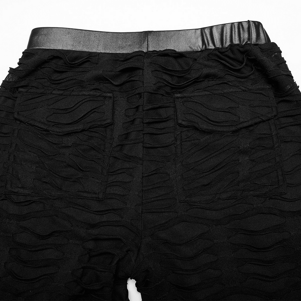 Back view of edgy ripped black leggings with metal rivets and textured fabric details.