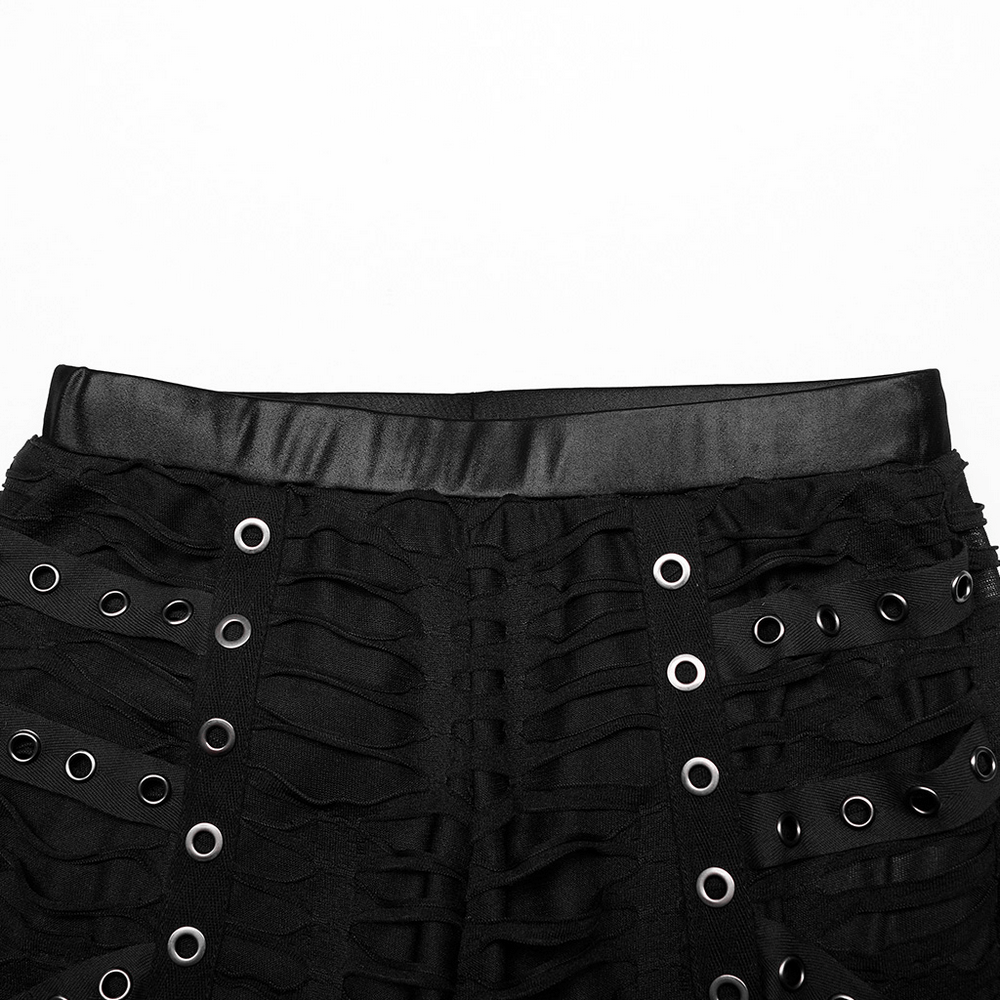 Close-up of edgy ripped black leggings with metal rivets and rings, featuring a double-layer elastic design.