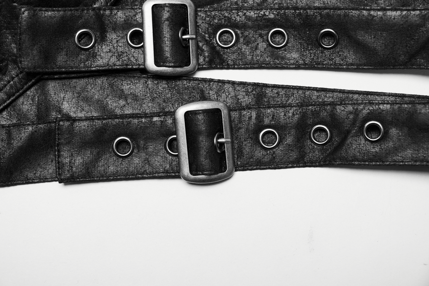 Close-up of adjustable black shoulder armor straps with silver buckles and grommets for gothic punk fashion.