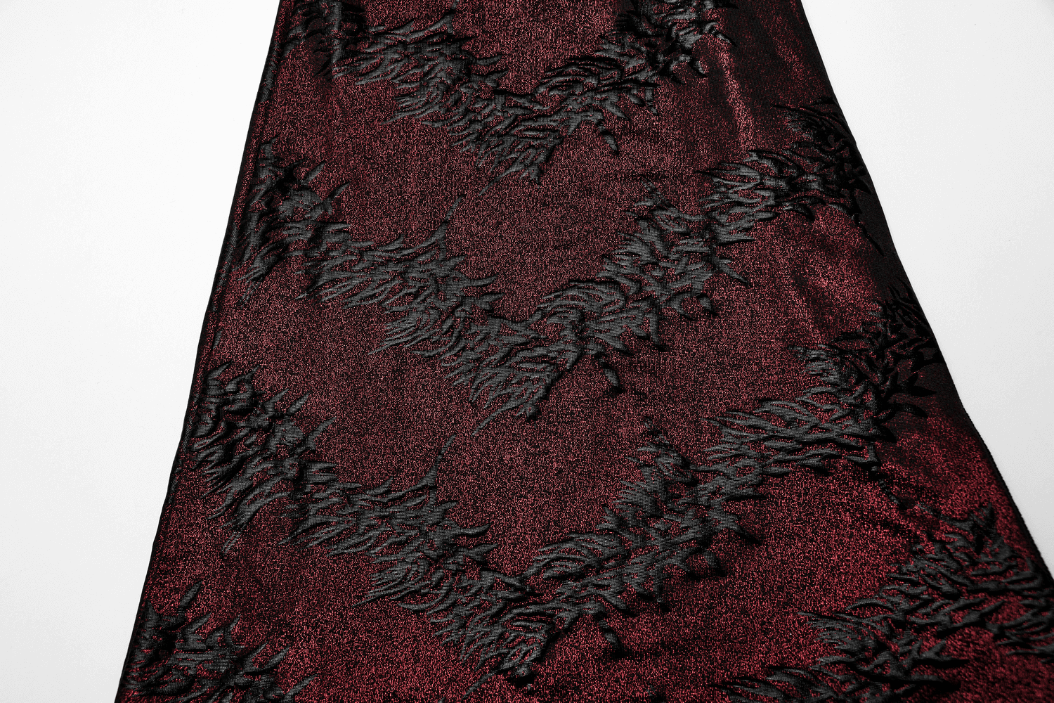 Close-up of dramatic red sparkly flared pants with textured lace detailing, showcasing an edgy style for women.