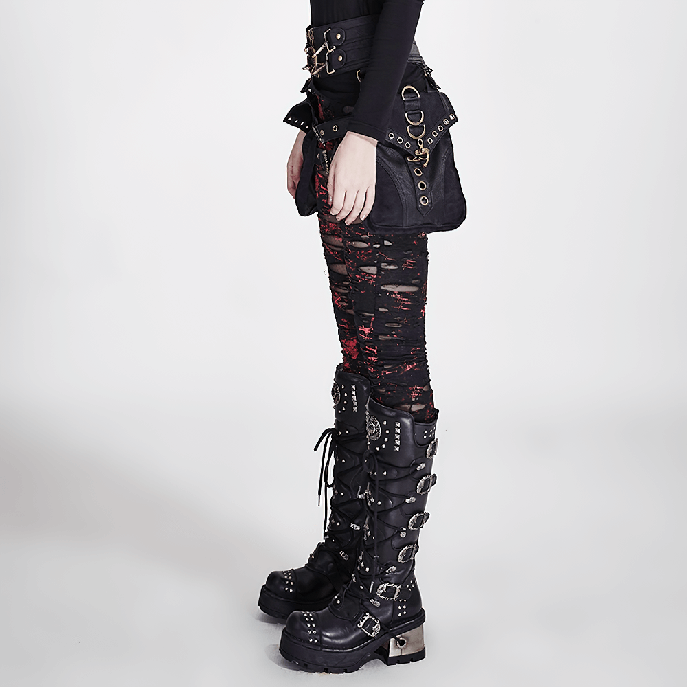 Side view of a model wearing edgy shredded black-red punk rock leggings paired with statement combat boots.
