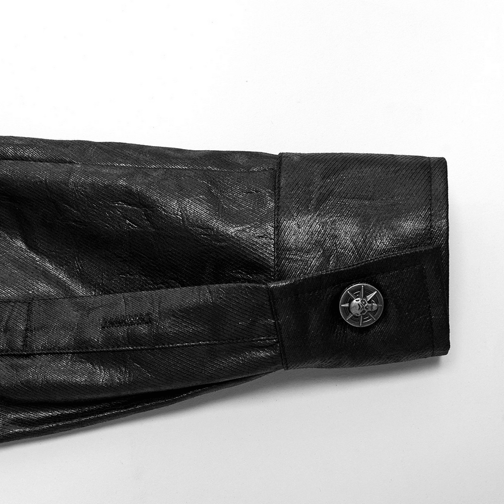 Close-up of the cuff featuring a skull button on a gothic leather shirt with a dragon scale texture.