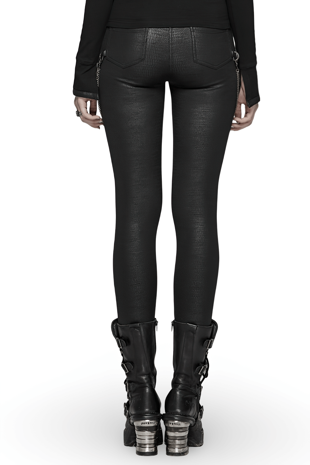 Back view of black elastic crackle PU leather leggings with chain detail, styled with chunky black boots.