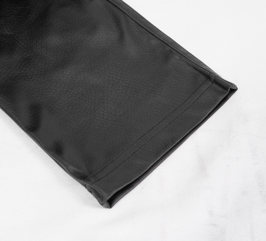 Close-up of the hem of black PU leather pants, showcasing the high-quality material and sleek design perfect for punk style.