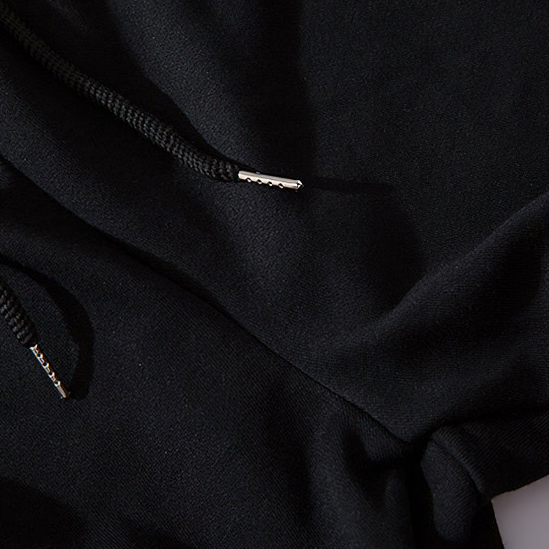 Close-up of black elastic joggers showing drawstrings and fabric texture for stylish streetwear.
