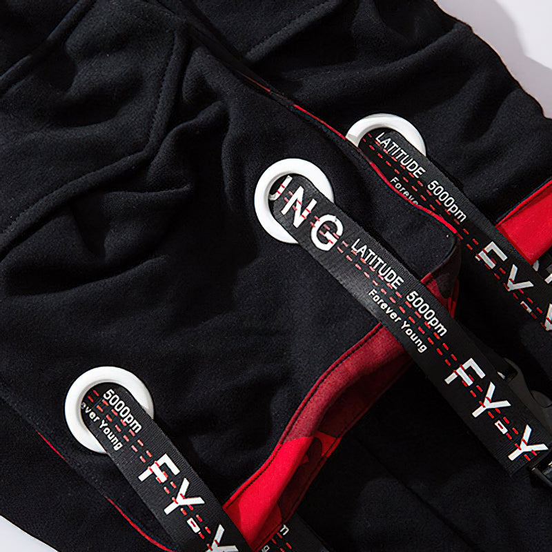 Close-up of elastic waist joggers with straps featuring 'Latitude' and 'Forever Young' labels, showcasing stylish pockets.