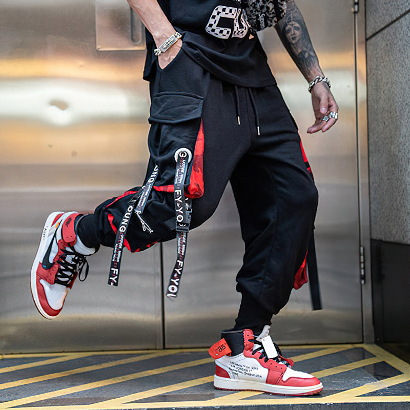 Stylish men's joggers with elastic waist, multi-pockets, and straps, paired with trendy sneakers.