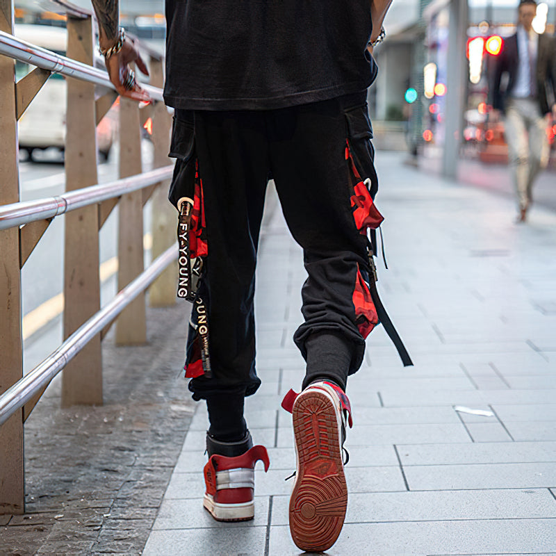 Men's black joggers with straps and pockets, perfect for streetwear style and casual outings.