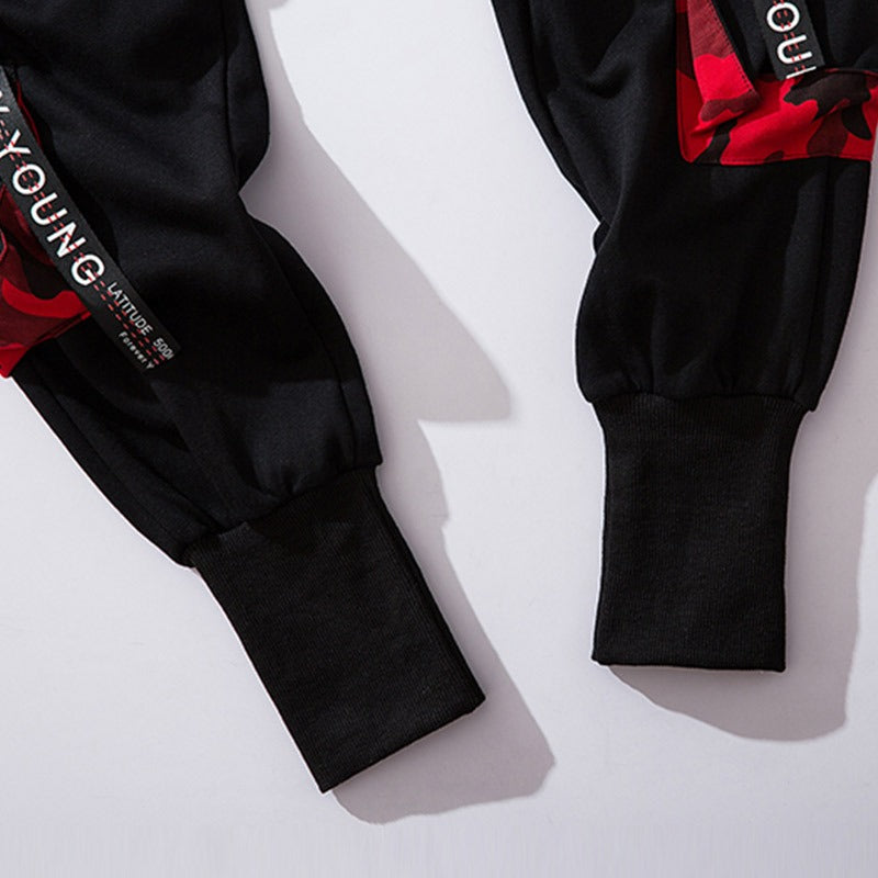 Close-up of black jogger cuffs with stylish straps and buckle details, showcasing casual streetwear fashion.