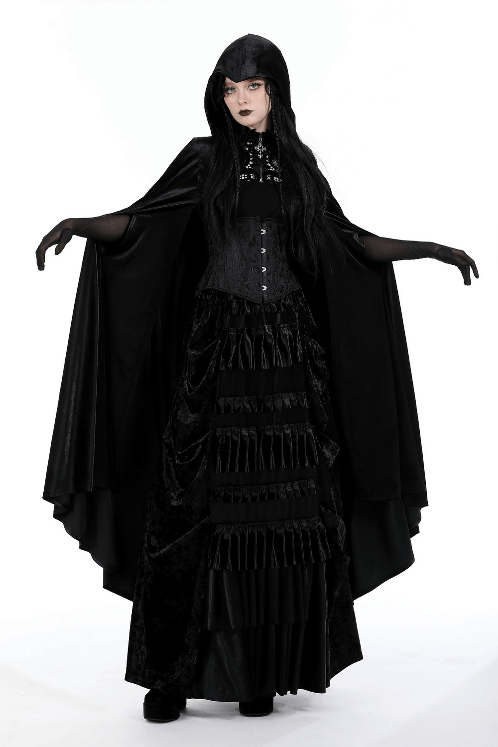 Gothic model wearing an elegant black velvet cape with hood, featuring dramatic styling and skull embroidery.