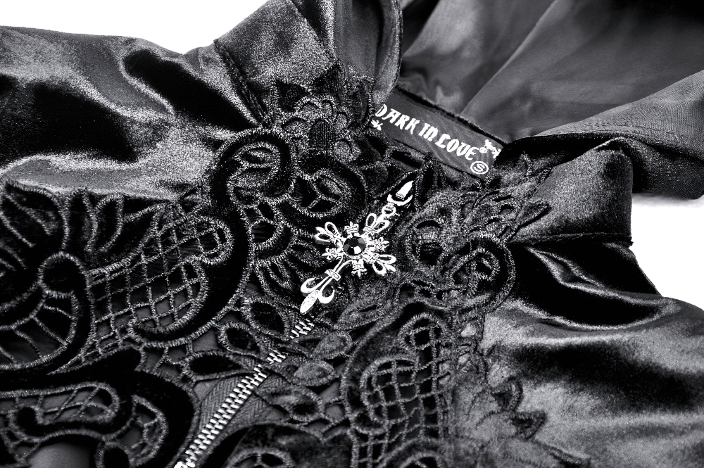 Close-up of elegant black velvet cape with intricate embroidery and hood, showcasing gothic style details.