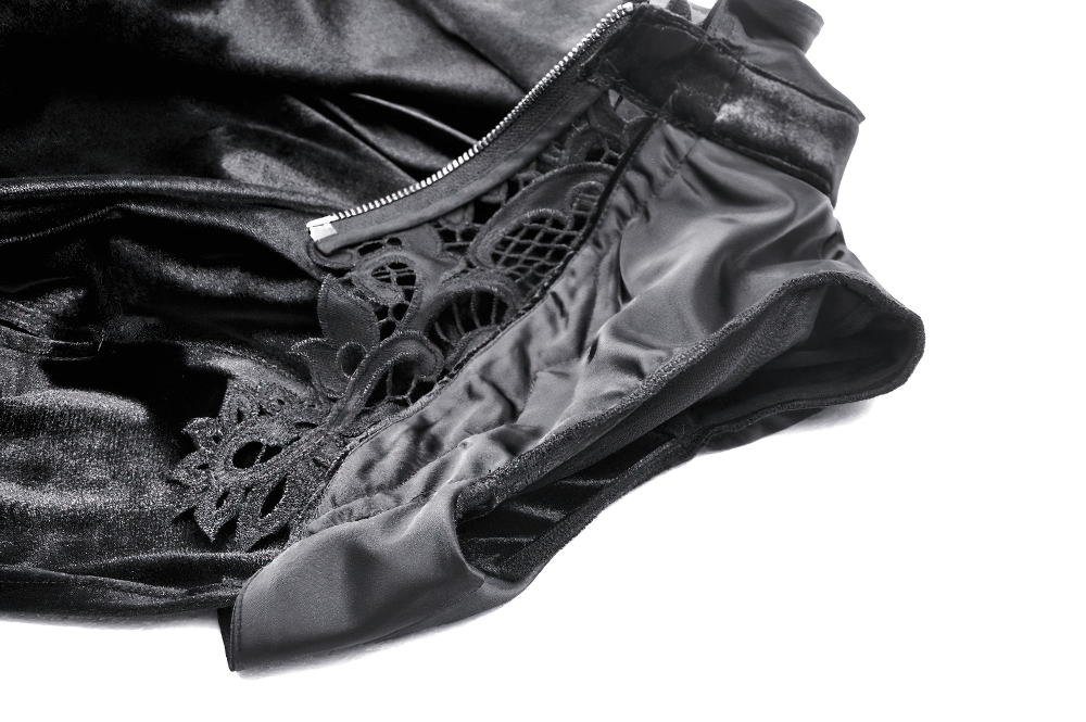Close-up of luxurious black velvet cape interior with intricate lace detailing and zipper.