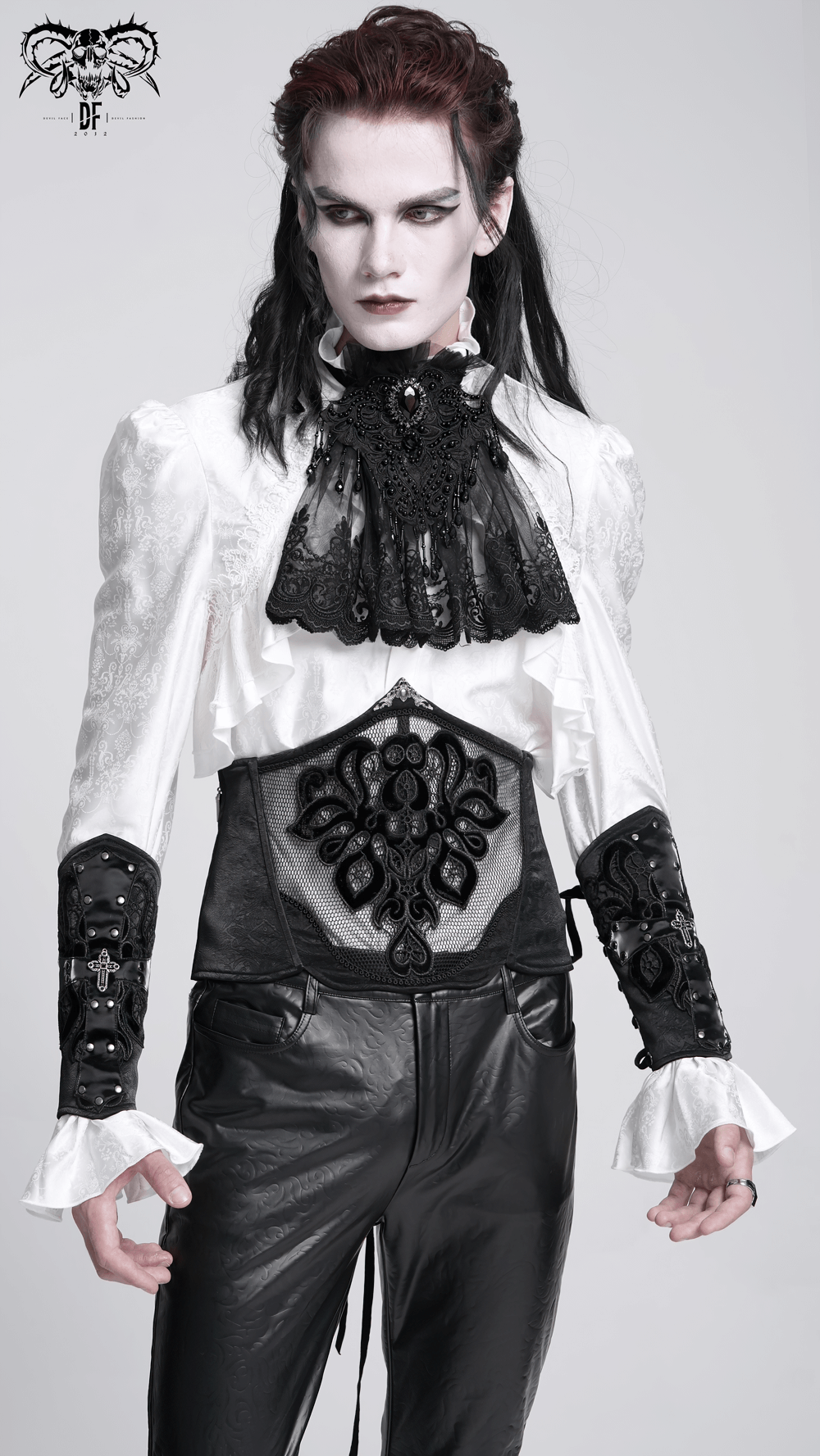 Gothic fashion model wearing an elegant black and white outfit with lace detailing, showcasing a bold, dark aesthetic.